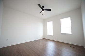 A bedroom with a ceiling fan and two windows at Wesley Place Apartments in Birmingham, AL